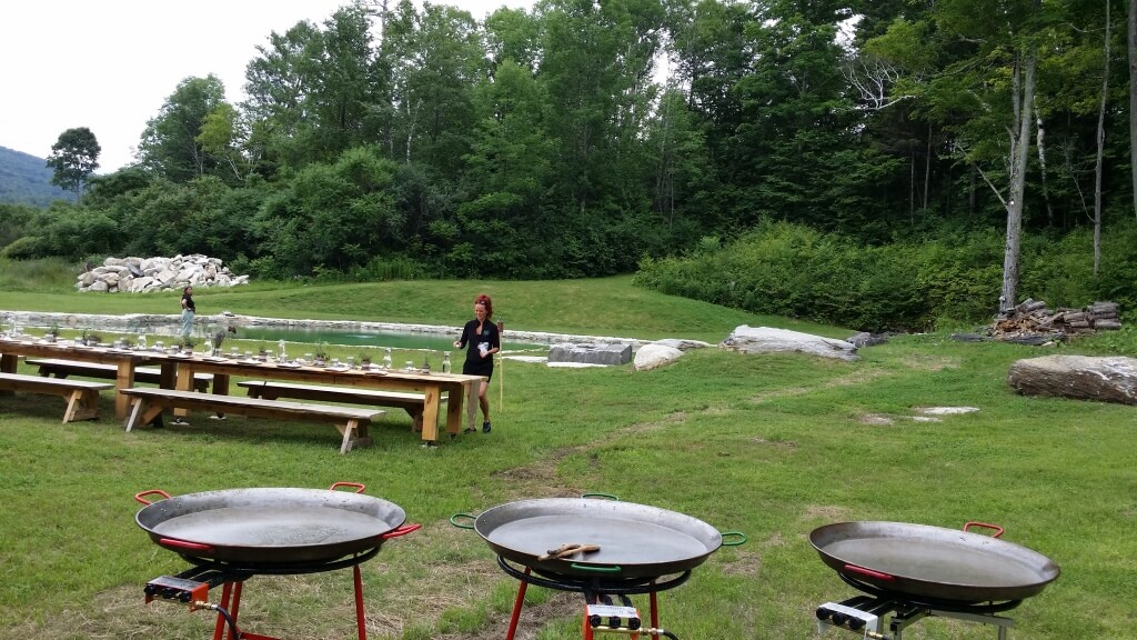Outdoor setup with tables and large pans.