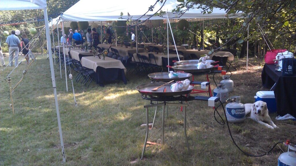 Outdoor gathering with tents and tables.