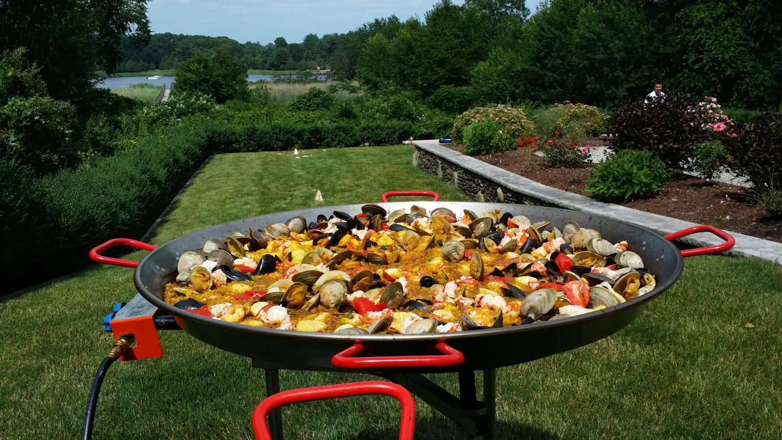 Paella in a big pan placed in a garden