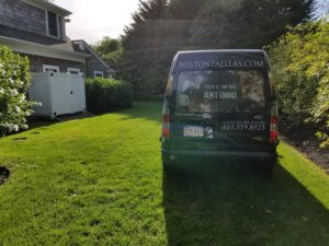 Van parked on grassy lawn near house.