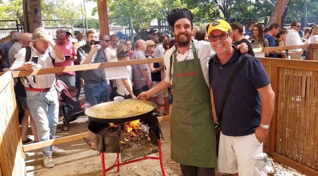 two men posing near a cooking pan