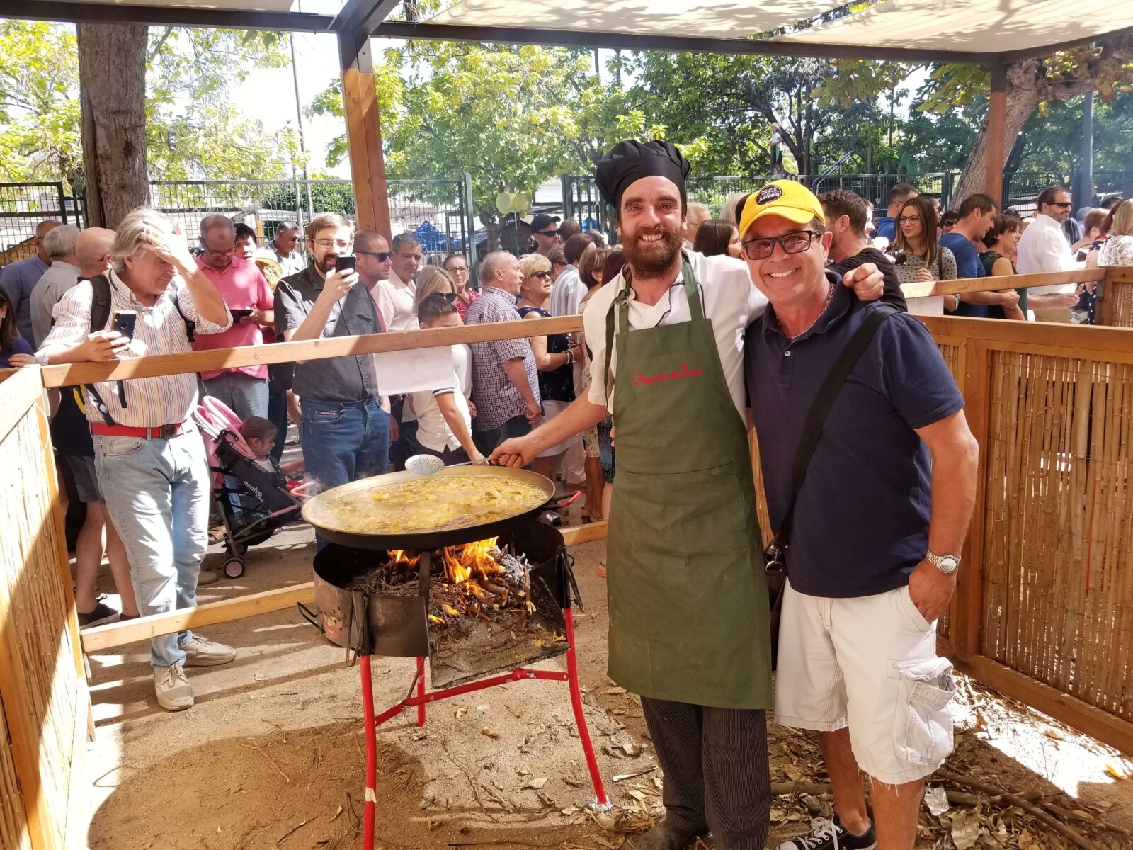 two men posing near a cooking pan