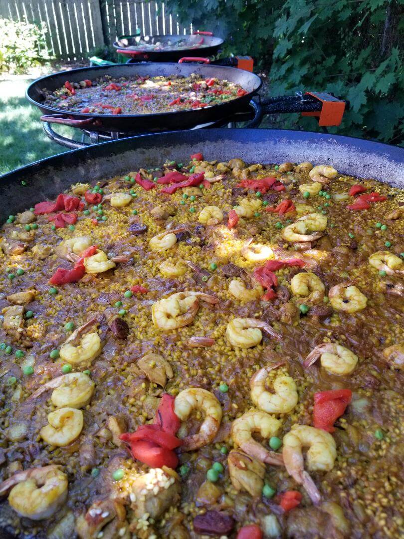 a pan of paella with red peppers and shrimp
