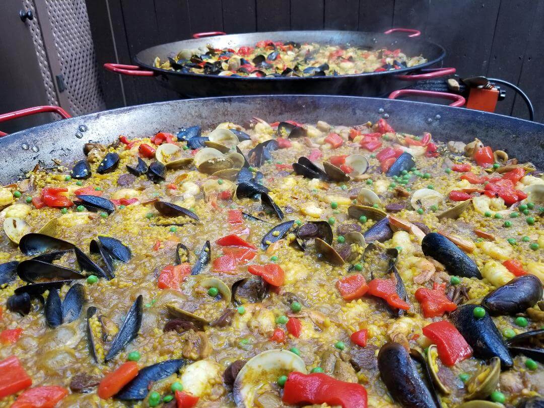 closeup of a paella pot with red peppers