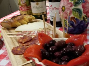 Tapas platter with wine and decorative pitcher.