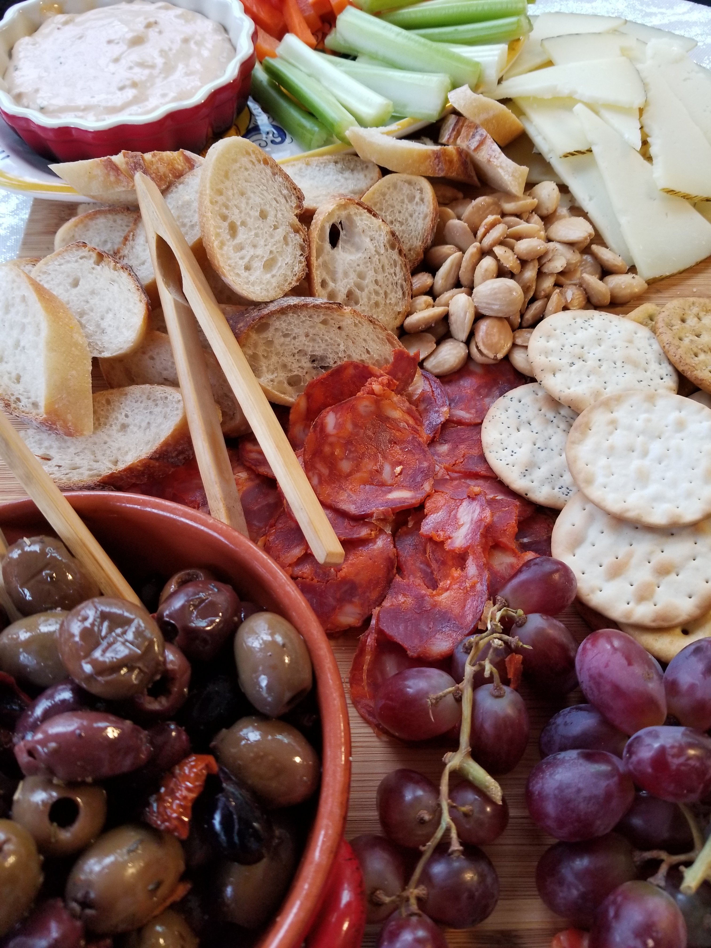 Closeup of the olives, grapes, crackers, and more food items