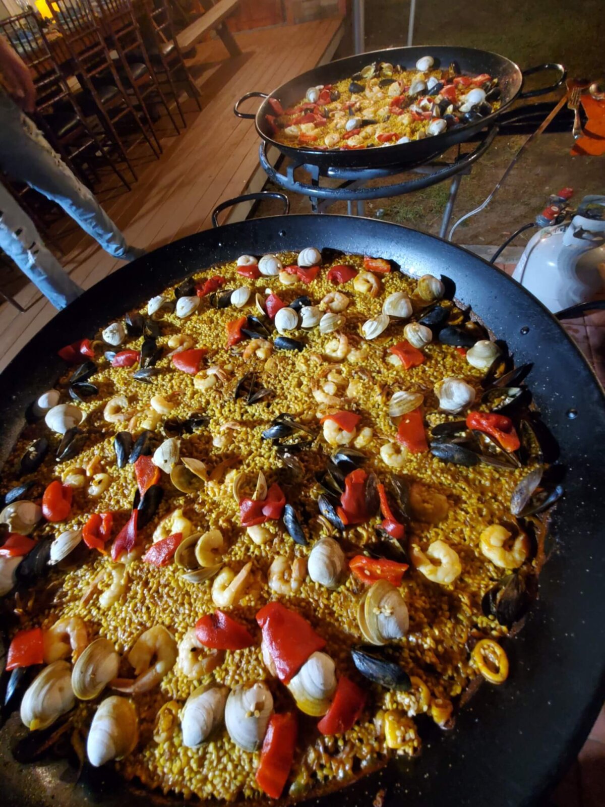Paella in two pans with shrimp and clams