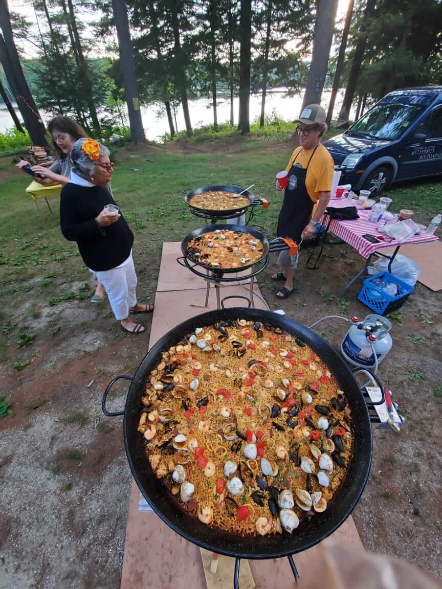 three big pans of Paella at a picnic spot