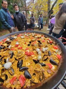 Paella dish served at outdoor gathering event.
