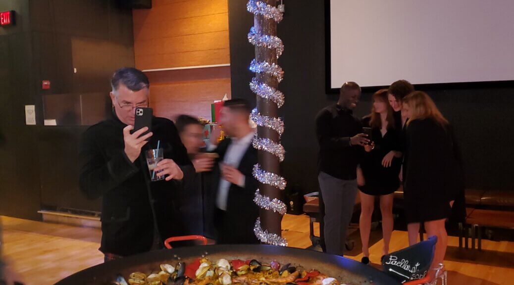 a man clicking a picture of a Paella