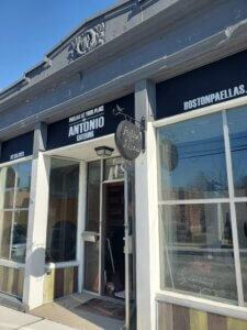 Restaurant storefront with large windows and signage.