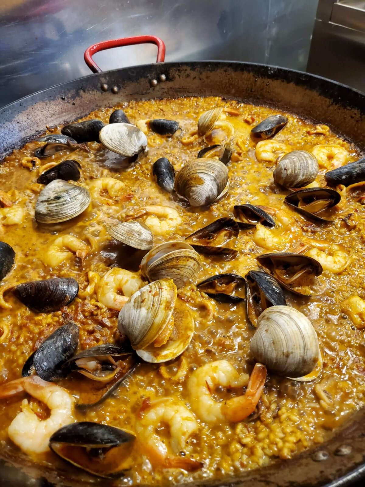 delicious Paella with shrimp and clams in a pan